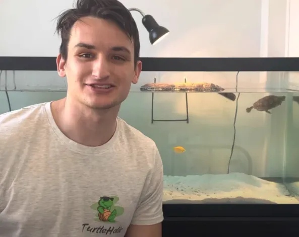 The owner of TurtleHolic beside his turtle aquarium